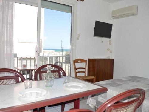 une salle à manger avec une table et des chaises et un balcon dans l'établissement Studio climatisé avec balcon et parking, à deux pas de la plage - FR-1-225D-125, à Saint-Cyprien