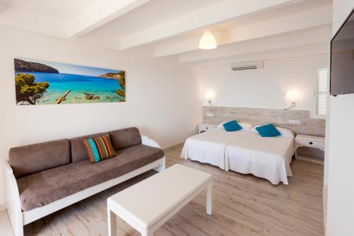 een woonkamer met 2 bedden en een bank bij Sun Club El Dorado - All Inclusive in Llucmajor