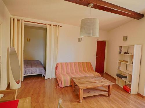 a living room with a table and a bed at Appartement Ajaccio, 1 pièce, 2 personnes - FR-1-61-473 in Ajaccio