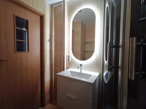 een badkamer met een wastafel en een spiegel bij Apartament Skałka in Świętochłowice