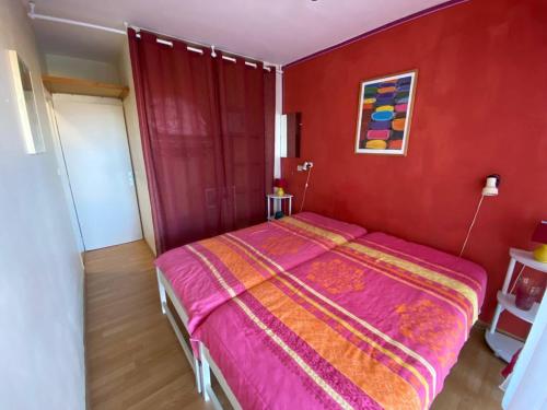 - une chambre rouge avec un lit dans une pièce dans l'établissement T3 pour 6 pers, vue mer et montagne, terrasse, parking, proche plage, Le Barcarès - FR-1-81-550, au Barcarès