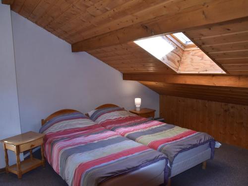 Ce lit se trouve dans un dortoir doté d'une lucarne. dans l'établissement Chalet de Luxe 6 Chambres, Proche Pistes avec WiFi, Babyfoot et Cheminée - FR-1-266-184, à Montgenèvre