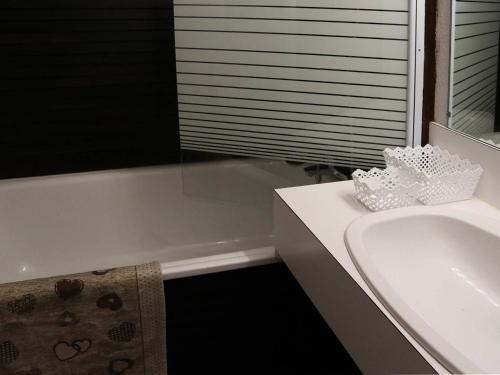 La salle de bains est pourvue d'une baignoire blanche, d'un lavabo et d'une baignoire. dans l'établissement Grand studio rénové, skis aux pieds, idéal famille, 6 pers, Les Orres - FR-1-322-469, aux Orres