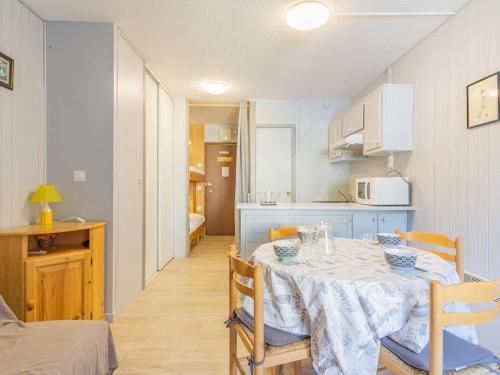 une salle à manger avec une table et une cuisine dans l'établissement Studio cosy avec balcon, centre-ville, proche télécabine, wifi inclus - FR-1-401-235, à Cauterets