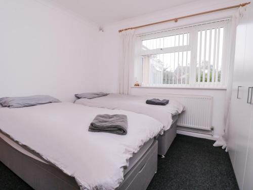 two twin beds in a room with a window at 1 Springfield Road in Margate