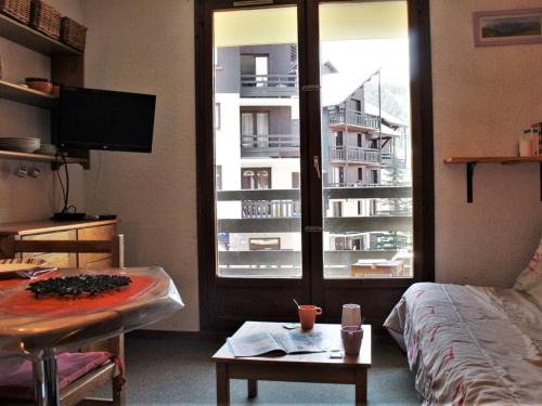 une chambre avec un lit, une table et une fenêtre dans l'établissement Studio cosy pour 4 au centre de Risoul, proche commerces et pistes - FR-1-330-550, à Risoul