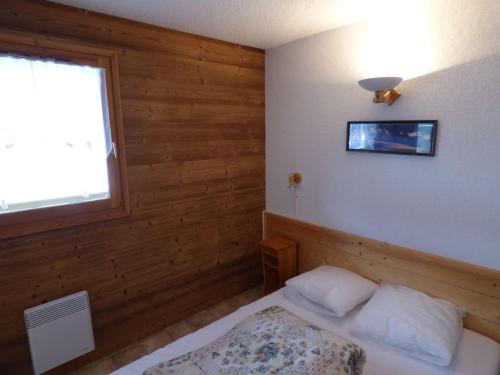 a small bedroom with a bed and a window at Appartement Le Grand-Bornand, 2 pièces, 4 personnes - FR-1-458-157 in Le Grand-Bornand