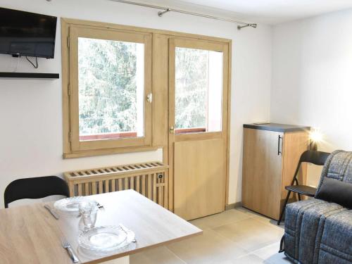 Cette chambre dispose d'une table, d'une fenêtre et d'une porte. dans l'établissement Studio Montagne Rénové, 2 Pers, Proche Pistes et Commerces, Méribel - FR-1-180-572, à Les Allues