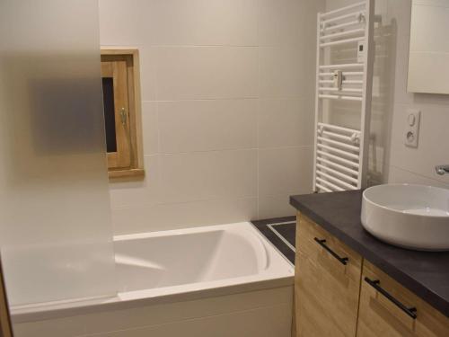 ein Badezimmer mit einer weißen Badewanne und einem Waschbecken in der Unterkunft Appartement Méribel, 1 pièce, 2 personnes - FR-1-180-572 in Les Allues