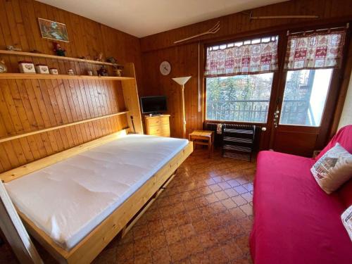 a bedroom with a large white bed and a couch at Appartement Le Grand-Bornand, 1 pièce, 4 personnes - FR-1-241-239 in Le Grand-Bornand