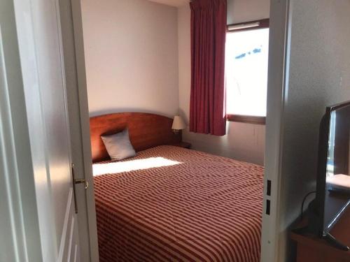 ラ・モンジーにあるAppartement cosy 4 pers. avec terrasse, piscine, fitness et parking - À 300m des pistes - FR-1-404-336の小さなベッドルーム(赤い毛布付きのベッド付)