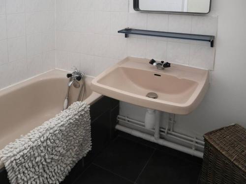 une salle de bain avec un lavabo et une baignoire dans l'établissement Studio 4 pers, balcon, pistes, commerces, animaux admis - FR-1-322-471, aux Orres