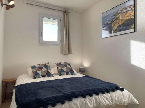 - une chambre avec un lit doté d'une couverture bleue dans l'établissement Appartement confortable 2 pièces avec balcon et parking, proche plage - FR-1-224-784, à Saint-Hilaire-de-Riez