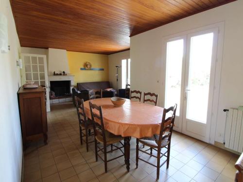 une cuisine et une salle à manger avec une table et des chaises en bois dans l'établissement Maison 5p pour 10, proche plage, pinède ombragée, animaux admis, Saint-Pierre-d'Oléron - FR-1-246A-88, à Saint-Pierre-dʼOléron