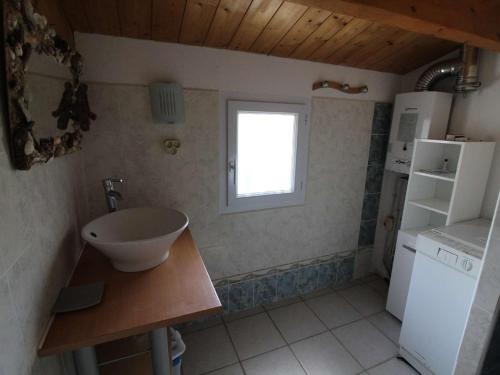 une petite cuisine avec un évier et un réfrigérateur dans l'établissement Maison 5p pour 10, proche plage, pinède ombragée, animaux admis, Saint-Pierre-d'Oléron - FR-1-246A-88, à Saint-Pierre-dʼOléron