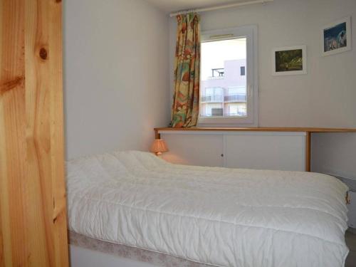 une chambre avec un lit blanc et une fenêtre dans l'établissement Appartement moderne 6 pers avec terrasse, parking et piscine à Saint-Cyprien - FR-1-225D-129, à Saint-Cyprien
