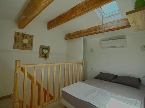 een slaapkamer met een bed in een kamer met houten balken bij Appartement Porticcio, 1 pièce, 3 personnes - FR-1-61-524 in Porticcio