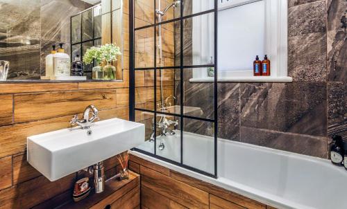 uma casa de banho com um lavatório e um chuveiro em KIRA Beach House, Large luxury 2 bedroom apartment em Hove