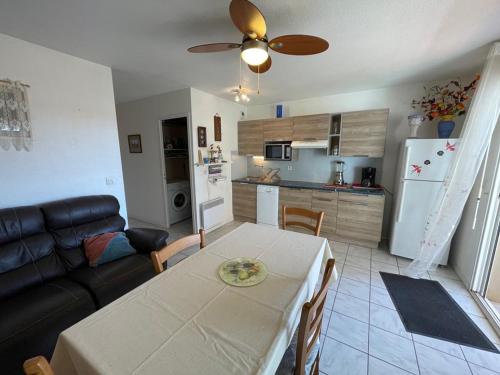 une cuisine et un salon avec une table et un canapé dans l'établissement Appart 3 Chambres, 6 Pers, Terrasse, Parking, Plage à proximité - FR-1-379-142, à Vieux-Boucau-les-Bains