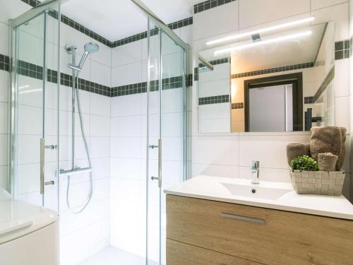 une salle de bain avec une douche, un lavabo et un miroir dans l'établissement Duplex 6 personnes, quartier thermal Saint-Lary, proche télécabine, calme, Pyrénées - FR-1-296-377, à Saint-Lary-Soulan