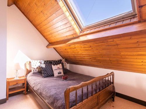 Cette chambre mansardée comprend un lit et une lucarne. dans l'établissement Duplex 6 personnes, quartier thermal Saint-Lary, proche télécabine, calme, Pyrénées - FR-1-296-377, à Saint-Lary-Soulan