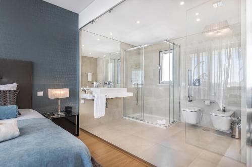 een grote badkamer met een douche, een bed en een wastafel bij ELLE Design Villa by OCvillas in Albufeira
