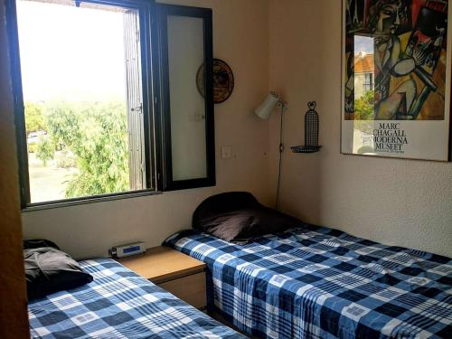 Cette chambre comprend 2 lits et une fenêtre. dans l'établissement Appartement 2 Pièces avec Terrasse, Accès Piscine et Activités Sportives - 4 Couchages, Clim en Option - FR-1-195-89, au Barcarès