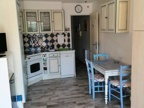 uma cozinha com armários brancos e uma mesa e cadeiras em Studio Amélie-les-Bains-Palalda, 1 pièce, 2 personnes - FR-1-659-16 em Amélie-les-Bains-Palalda