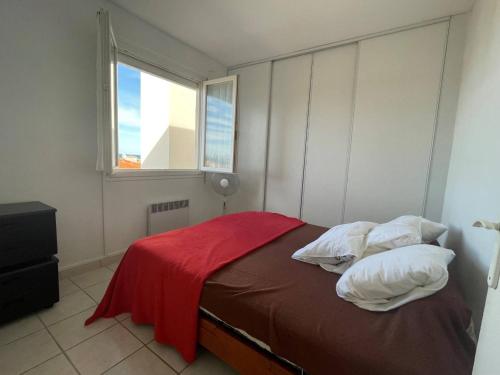 une chambre avec un lit avec une couverture rouge dessus dans l'établissement Appartement 2 pièces avec balcon, parking, à 2 pas de la plage - FR-1-225D-133, à Saint-Cyprien