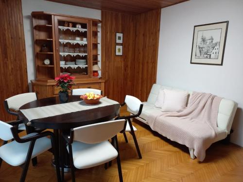 a living room with a table and chairs and a couch at Riverside Villa Avo - Apartment AVO in Spodnja Idrija