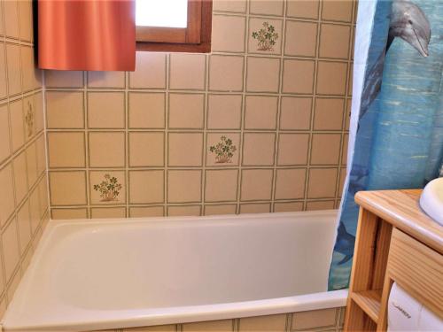 La salle de bains est pourvue d'une baignoire et d'un rideau de douche. dans l'établissement Appartement Risoul, 2 pièces, 6 personnes - FR-1-330-553, à Risoul