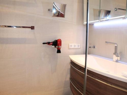 La salle de bains est pourvue d'un lavabo. un extincteur rouge dans l'établissement Appartement Moderne avec Terrasse et Garage - Villeneuve-Loubet - FR-1-252A-72, à Villeneuve-Loubet