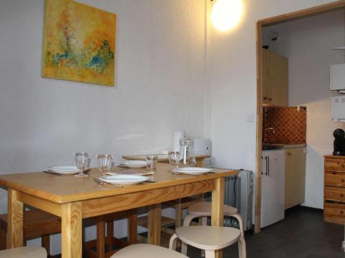 - une table en bois avec des chaises et des verres à vin dans l'établissement Studio cabine au pied des pistes, 4 couchages, plein centre, balcon exposé Ouest, parking proche - FR-1-330-554, à Risoul
