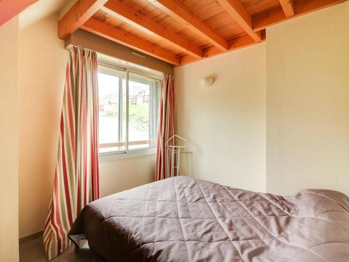 1 dormitorio con cama y ventana en Appartement La Mongie, 3 pièces, 8 personnes - FR-1-404-337, en Bagnères-de-Bigorre