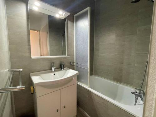 une salle de bain avec un lavabo, une baignoire et un miroir dans l'établissement Appartement cosy avec piscine, terrasse et parking - 250m de la plage - 6 pers. - FR-1-225D-141, à Saint-Cyprien