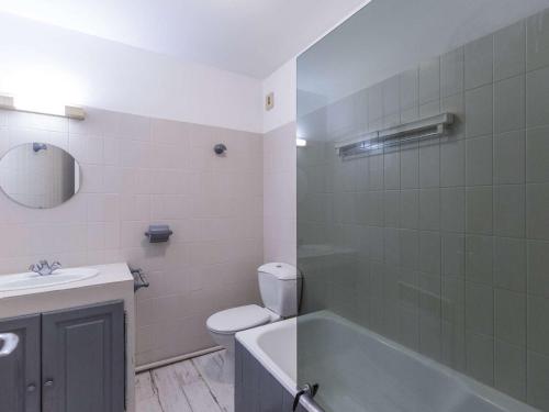 a bathroom with a tub and a toilet and a sink at Appartement Cauterets, 3 pièces, 4 personnes - FR-1-401-240 in Cauterets