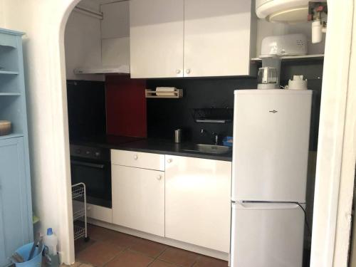 een keuken met witte kasten en een witte koelkast bij Appartement Prats-de-Mollo-la-Preste, 2 pièces, 5 personnes - FR-1-659-58 in Prats-de-Mollo-la-Preste