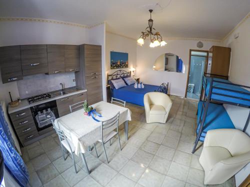 a kitchen and a living room with a table and a bed at B&B La Strea in Porto Cesareo