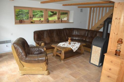 a living room with a leather couch and a table at Chata Dolce in Trutnov