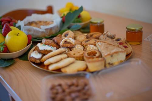 um prato de pastelaria e outros alimentos sobre uma mesa em Agriturismo i doni del mandorlo em Alghero