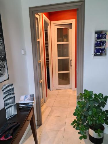 un pasillo con una puerta, una mesa y una planta en Suite indépendante avec 1 chambre et 1 bureau, en Montpellier