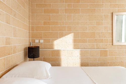 a bedroom with a brick wall and a bed at Appart Hôtel Résidence Courcelle in Levallois-Perret