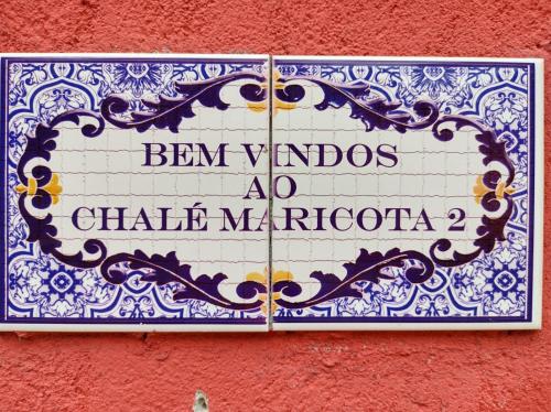 a sign on the side of a red wall at CHALÉS MARICOTA in Vargem Bonita