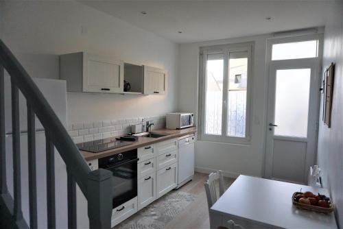 a kitchen with a sink and a stove top oven at Les Beaux Jours, Tours, le Duplex in Tours
