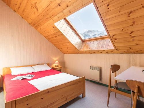 een slaapkamer met een bed, een bureau en een raam bij Charmant Duplex 3 Pièces avec Mezzanine, Balcon et Proximité Pistes - 6 Couchages - FR-1-330F-138 in Le Monêtier-les-Bains