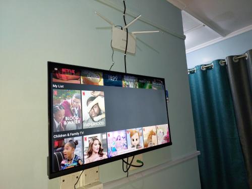 a flat screen tv hanging on a wall at Essie Studios Naivasha CBD in Naivasha