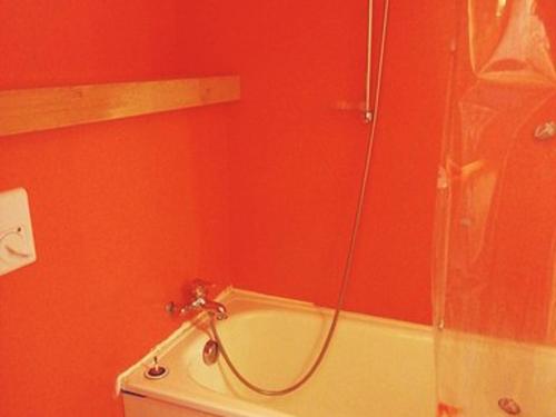 La salle de bains rouge est pourvue d'une douche et d'une baignoire. dans l'établissement Studio cosy 4 pers, Arcs 1800, proche pistes et commerces - FR-1-411-257, à Arc 1800