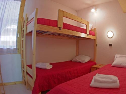 ヴァルモレルにあるAppartement Valmorel, 2 pièces, 5 personnes - FR-1-291-822の赤いシーツが備わるドミトリールームの二段ベッド2台分です。