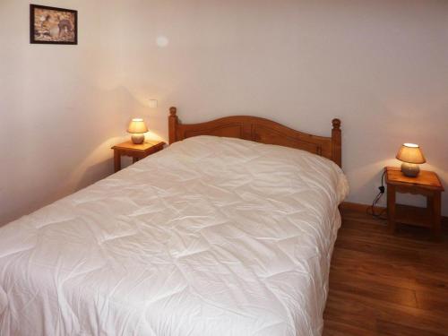 ein Schlafzimmer mit einem weißen Bett mit zwei Lampen an Tischen in der Unterkunft Appartement Les Orres, 2 pièces, 6 personnes - FR-1-322-330 in Les Orres