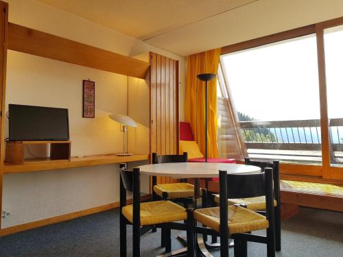une pièce avec une table, des chaises et une fenêtre dans l'établissement Studio cosy pour 4 à Arc 1600 proche pistes et commerces - FR-1-411-536, à Arc 1600